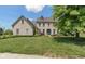Charming two-story brick home with a manicured front lawn and a welcoming blue front door at 8754 Lily Ct, Zionsville, IN 46077
