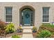 A charming front entrance with a blue door framed by an arched brickway and decorative plants at 8754 Lily Ct, Zionsville, IN 46077