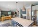 Open kitchen and living area features an eat-in island with white countertops and pendant lighting at 8754 Lily Ct, Zionsville, IN 46077