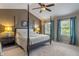 This spacious main bedroom features a ceiling fan, large windows with curtains, and a four-poster bed at 8754 Lily Ct, Zionsville, IN 46077