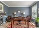 Home office with hardwood floors, desk, chairs, and natural lighting at 8754 Lily Ct, Zionsville, IN 46077