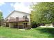 Backyard view of home featuring a wood deck, green lawn, and lush trees at 9323 Doubloon Rd, Indianapolis, IN 46268