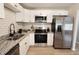 The modern kitchen offers white cabinetry, stainless steel appliances and stone countertops at 9323 Doubloon Rd, Indianapolis, IN 46268