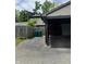 View of covered carport and driveway alongside a fenced yard with trash receptacles at 9458 Fordham St, Indianapolis, IN 46268