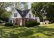 Charming two-story home featuring a combination of brick and siding, complemented by a lush green lawn and mature trees at 980 W Poplar St, Zionsville, IN 46077