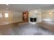 Bright, open-concept living area featuring a fireplace, neutral carpet, and views into the adjacent kitchen at 980 W Poplar St, Zionsville, IN 46077