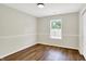 Bright bedroom with a chair rail, large window, and lovely wood-look floors at 9936 Waterside Dr, Noblesville, IN 46060