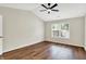 Bright bedroom boasts a ceiling fan, large window, and lovely wood-look floors at 9936 Waterside Dr, Noblesville, IN 46060