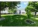 Lush green backyard featuring a trampoline and manicured lawn with mature trees at 10539 Ross Xing, Fishers, IN 46038