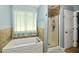 Well lit bathroom featuring a bathtub and glass door shower at 10539 Ross Xing, Fishers, IN 46038