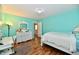 Bright bedroom with a light blue accent wall, white furniture, and wood laminate flooring at 10539 Ross Xing, Fishers, IN 46038