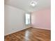Bare bedroom with a pink accent wall, wood flooring, and a chandelier at 10539 Ross Xing, Fishers, IN 46038