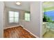 Hallway view of decorated bedrooms and a bathroom with wood laminate flooring at 10539 Ross Xing, Fishers, IN 46038
