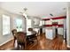Eat-in kitchen with wood floors, white cabinets, stainless steel appliances, and a red accent wall at 10539 Ross Xing, Fishers, IN 46038