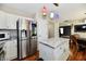 Kitchen with stainless steel refrigerator, granite island, hardwood floors, and pendant lighting at 10539 Ross Xing, Fishers, IN 46038