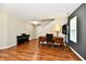 Open living room featuring hardwood floors, a classic wood desk, piano, and stairs leading upstairs at 10539 Ross Xing, Fishers, IN 46038