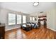 Inviting living room featuring hardwood floors, a comfortable sofa, and an open view to the kitchen at 10539 Ross Xing, Fishers, IN 46038