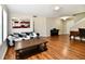Inviting living room featuring hardwood floors, comfortable sofa, and views of the kitchen and stairs at 10539 Ross Xing, Fishers, IN 46038
