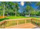 A backyard boasts lush greenery, mature trees, a wood fence, and a deck, perfect for outdoor enjoyment at 11 N Restin Rd, Greenwood, IN 46142