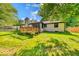 The backyard features a well-maintained lawn, mature trees, a deck and a brick house exterior at 11 N Restin Rd, Greenwood, IN 46142