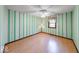 Bedroom features stylish striped wallpaper, wood-look floors, and a window at 11 N Restin Rd, Greenwood, IN 46142