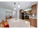 Kitchen island featuring stone countertops, pendant lights, and wooden cabinets at 11 N Restin Rd, Greenwood, IN 46142