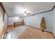 Large, airy living room featuring neutral carpet, a ceiling fan, and access to stairs at 11 N Restin Rd, Greenwood, IN 46142