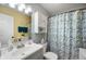Bright bathroom with a grey vanity, floral shower curtain, and coordinated colors at 1112 Berwyn Rd, Whiteland, IN 46184