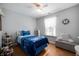 Cozy bedroom featuring a twin bed with blue bedding, hardwood floors, and natural light at 1112 Berwyn Rd, Whiteland, IN 46184