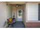 Inviting front porch features a cozy bench, decorative wreath, and pleasant natural light at 1112 Berwyn Rd, Whiteland, IN 46184