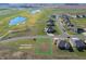 Aerial view of a large vacant lot near houses, green golf courses, and a pond at 1130 Constitution Dr, Edinburgh, IN 46124