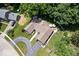 Drone eye view of a house with circular driveway, brown roof, green lawn, and patio at 12674 Banbury Cir, Carmel, IN 46033