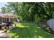 Expansive backyard featuring a lush lawn, stone patio, mature trees, and privacy fence at 12674 Banbury Cir, Carmel, IN 46033