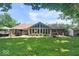 Expansive backyard with patio, outdoor dining, lush lawn, and rear view of home at 12674 Banbury Cir, Carmel, IN 46033