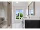 Bright bathroom with white marble floors, modern vanity, and large window offering scenic backyard views at 12674 Banbury Cir, Carmel, IN 46033