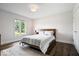 Sun-filled bedroom featuring hardwood floors, a comfortable queen bed, and a view of the outdoors at 12674 Banbury Cir, Carmel, IN 46033