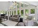 Sun-drenched sunroom with expansive windows, comfortable seating, and views of the lush backyard at 12674 Banbury Cir, Carmel, IN 46033