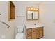 Bathroom vanity with wooden cabinets, a sink, and a lighted mirror provides ample storage space at 13 Marywood Dr, Greenfield, IN 46140