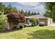 Charming brick home featuring a lush front yard with mature trees and manicured landscaping at 13 Marywood Dr, Greenfield, IN 46140