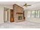 Comfortable living space with brick fireplace, ceiling fan, and ample natural light at 13 Marywood Dr, Greenfield, IN 46140