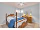 Bright bedroom featuring a ceiling fan and a wooden-framed bed and dresser at 1340 Eustis Dr, Indianapolis, IN 46229