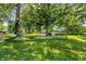 Lush front yard with mature trees, manicured lawn, and partial view of the home at 1340 Eustis Dr, Indianapolis, IN 46229