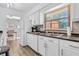 View of a bright kitchen featuring white cabinets and appliances with access to the dining room at 1340 Eustis Dr, Indianapolis, IN 46229