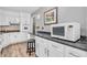 Kitchen view with white cabinets, dark countertops, and modern appliances in a well-lit space at 1340 Eustis Dr, Indianapolis, IN 46229