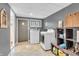 Spacious laundry room with modern washer and dryer, tile flooring, utility sink, and shelving at 1340 Eustis Dr, Indianapolis, IN 46229