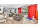 Cozy living room with hardwood floors, neutral gray walls, and bright window with red curtains at 1340 Eustis Dr, Indianapolis, IN 46229
