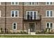 Charming brick townhome featuring a balcony, stylish windows, and a landscaped front yard with a welcoming entrance at 1461 Whistle Way, Westfield, IN 46074