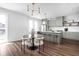 Open-concept kitchen and dining area featuring modern light fixtures, light green cabinets and wood flooring at 1461 Whistle Way, Westfield, IN 46074