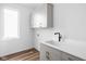 Laundry room with white cabinets and gray cabinets below the quartz countertop at 1461 Whistle Way, Westfield, IN 46074