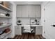 Well-lit home office with floating shelves, upper cabinets, stylish desk, and wood floors at 1461 Whistle Way, Westfield, IN 46074
